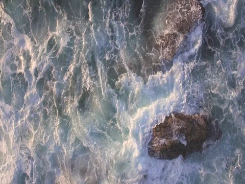Rising birds eye view of waves crashing on the rocks Stock Footage 82734656