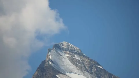 Rising clouds cling to top of mountain by standing still. Video stock 335707208