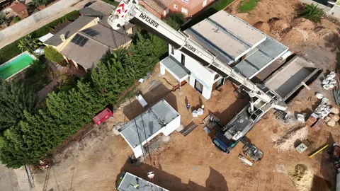 Rising up crane boom arm installing modular home on construction site lot Vídeos de archivo 224336865