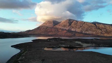 Rising drone approach toward Arkle with downward tilt over Loch Stack Stock Footage 323367655