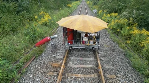 Rising drone over railway construction cart revealing rails in the distance Stock Footage 249266381
