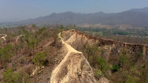 Rising drone shot tilting down, showing the steep drop offs the side of Stock Footage 256949305