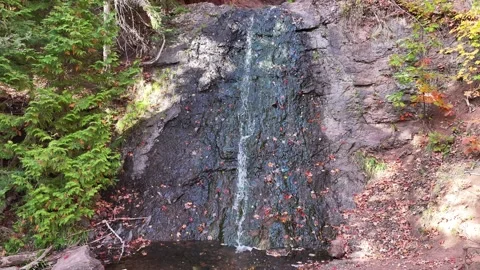 Rising Drone of Stream Running Down Red Rocks with Vibrant Autumn Colors Aerial Stock Footage 315265480