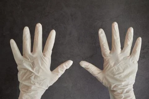 Rising hands wearing white disposable latex glove protection from Coronavirus Stock Photos