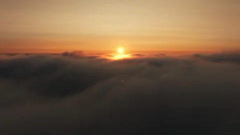 Rising high above the clouds revealing a sunset Stock Footage 258272349