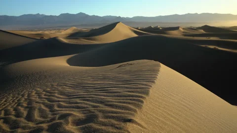 Rising over a dune field bathed in morning light. Stock Footage 154973014