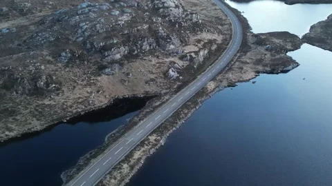 Rising pullback drone over A838 NC500 road at Loch na Thull, Sutherland Stock Footage 323435034