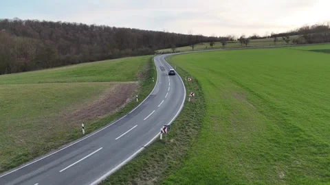 Rising road perspective above bend with passing vehicle Stock Footage 331212052