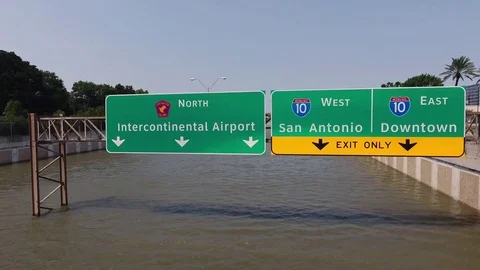 Rising shot of freeway sign above Hurricane Harvey flood waters in Houston Video stock 84747448