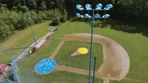 Rising Slowly Over Light Tower at Baseball Field Vidéo 124369564