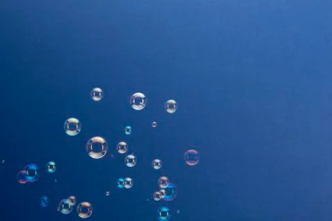 Rising Soap Bubbles Over Blue Background Stock Photos