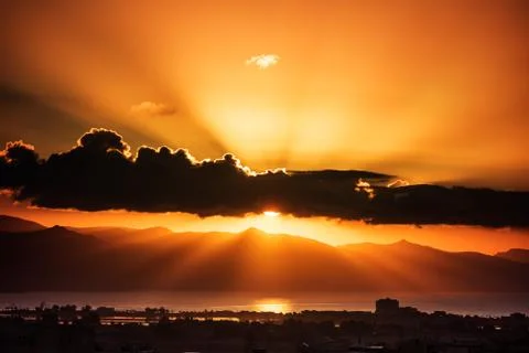 The rising sun behind the clouds with rays of light similar to an explosion Stock Photos