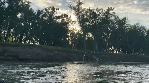 The rising sun peeks through the trees along the Missouri River in North Dakota Stock Footage 146194872