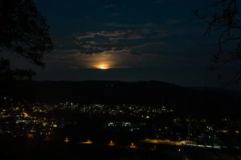 Rising super moon with clouds over cityscape. 스톡 사진