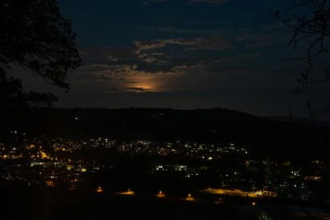 Rising super moon with clouds over cityscape. Stock Photos