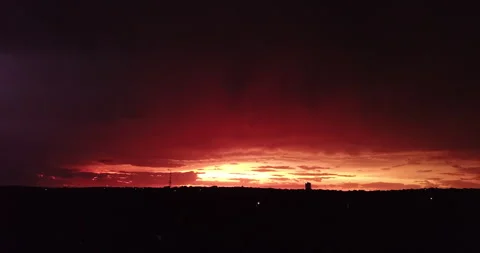 Rising Through Trees to Stunning Red Sunset and Streaks of Lightning Stock Footage 313857434