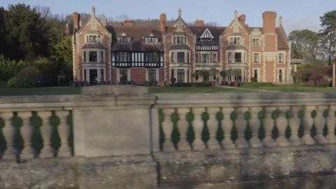 Rising tracking shot behind stone to reveal Victorian mansion Wood Norton Hall 스톡 동영상 284247247