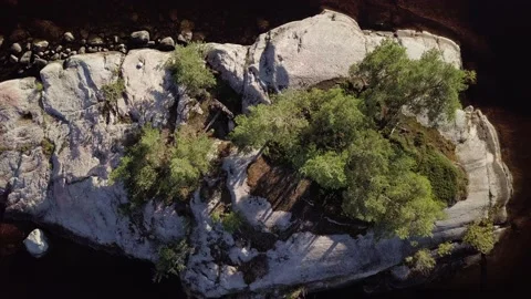 Rising vertical aerial view of small rocky island Stock Footage 157007563