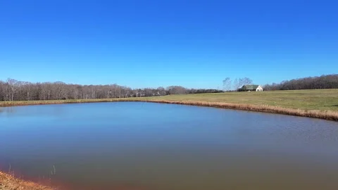 Rising Vertical View Of A Pond With A House In The Distance Stock Footage 296931996