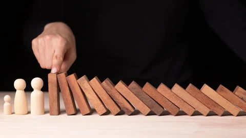 Risk Management in Decision Making Hand Stopping Falling Dominos in a Business Stock Footage 296262299