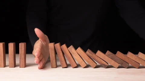 Risk Management Hand Stopping Falling Dominos in a Business Crisis Slow Motion Stock Footage 296262344