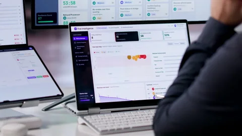 Risk Manager Analyzing Compliance Data On Dual Screen Laptop Stock Footage 340398291