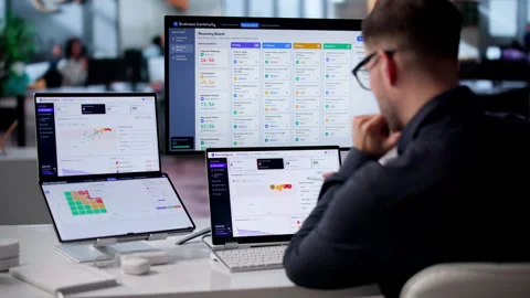 Risk Manager Analyzing Compliance Data On Dual Screen Laptop Stock Footage 342960271