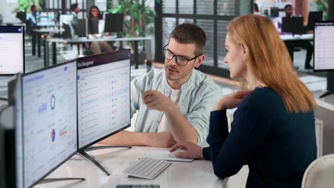 Risk Manager Analyzing Enterprise Strategy Using Multiple Computer Screens Stock Footage 333842094