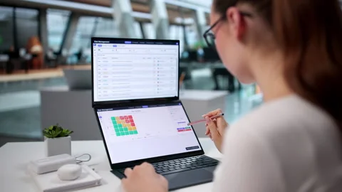 Risk Manager Carefully Analyzing Data On Dual Touchscreen Laptop Stock Footage 345329464