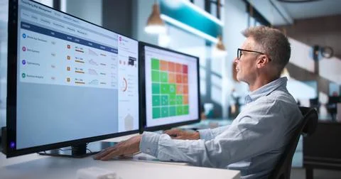 Risk Manager Carefully Reviewing Third-party Compliance Data On Computer. Stock Photos