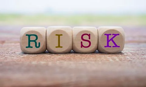 Risk word written on cube shape wooden blocks on wooden table.  Stock Photos