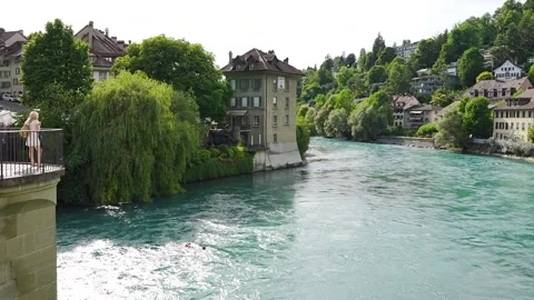 River Aare in bern viewed from a bridge with people swimming in it pan Right Stock Footage 345620068