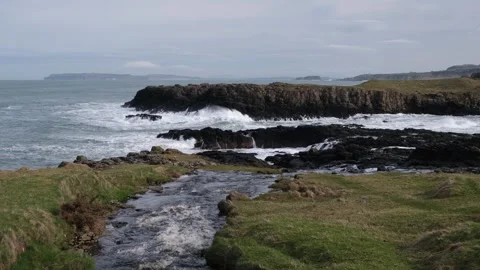 River above Dunseverick Falls flowing towards the dramatic Atlantic Ocean Video stock 303451221