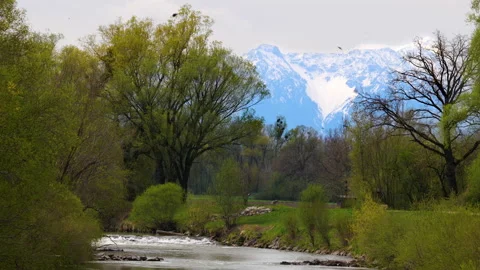 The river Ammer during spring with snow-covered  mountains in the background Stock Footage 153682680
