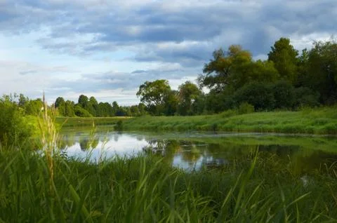 River and cloudy sky on summer evening Stock Photos