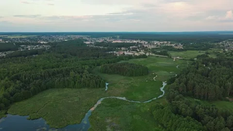 River and lake in the middle of fields and forest. Aerial sunrise shot Stockbeeldmateriaal 170137847