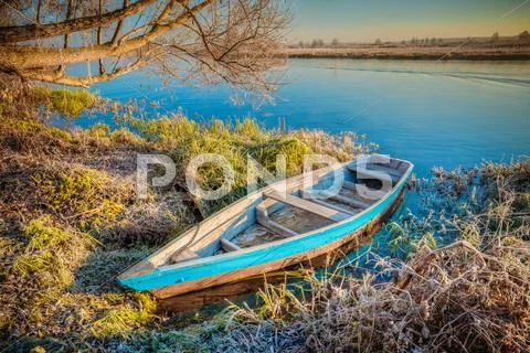 River and old wooden rowing fishing boat at beautiful sunrise in Stock Photos