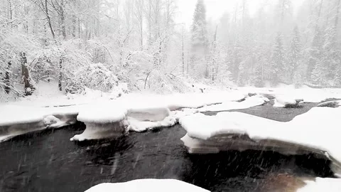 River and snowfall. Winter landscape. Snowflakes fall in flakes. Video stock 150333032
