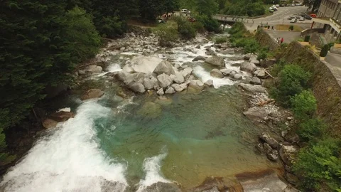 River and waterfalls flowing next to a village Stock Footage 103706944