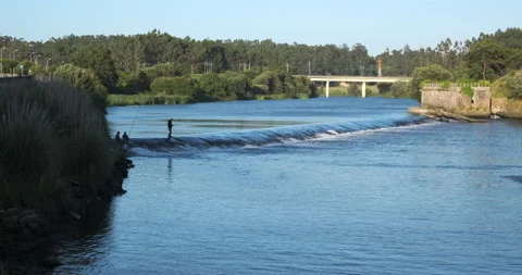 River Ave in Vila do Conde, Portugal with men fishing in the distance Stock Footage 132231485