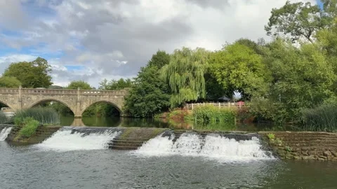 River Avon flowing over weir on sunny summer day Stock Footage 328730409