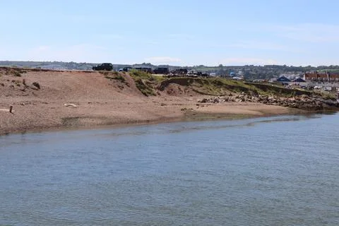 The river Axe flows quickly as it travels towards the sea Stock Photos