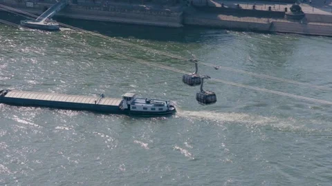 River Barge Navigates Under Cable Cars in Busy Urban Waterway, Aerial View Stock Footage 334054265