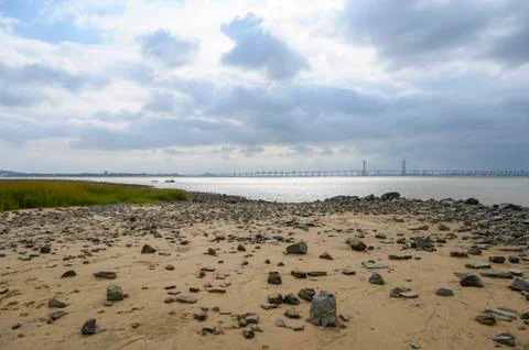 River beach and distant bridge Stock Photos