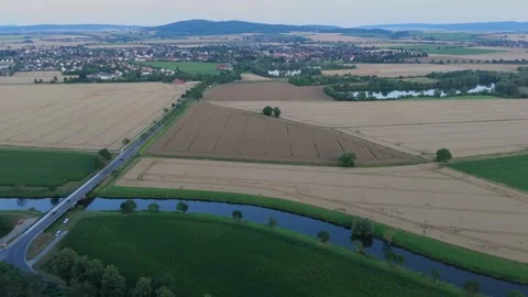 River bend road and farm fields with a town on the horizon Video stock 340159690