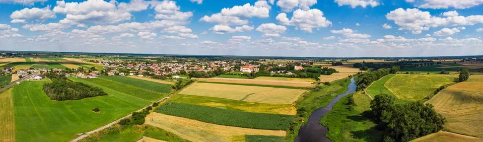 The River between the fields in summer with the town in the background Stock Photos