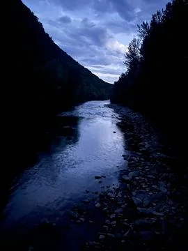 River between mountains in the blue hour of the day. Stock Photos