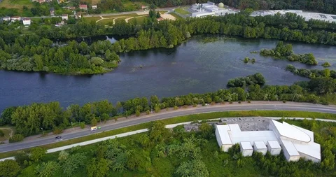 A RIVER BETWEEN ROAD AND FACTORY IN SUMMER Stock Footage 92576135