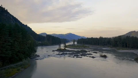 River between tree forest at sunset. Altai Russia. Mountain range in background. Stock Footage 121368251