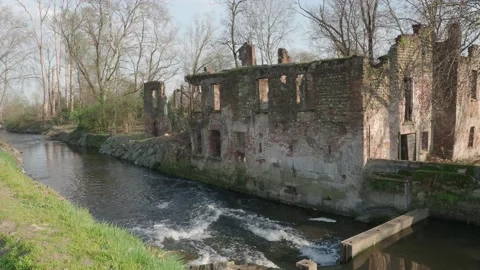 River between woods with the remains of a brick mill on the bank Stock Footage 150680779